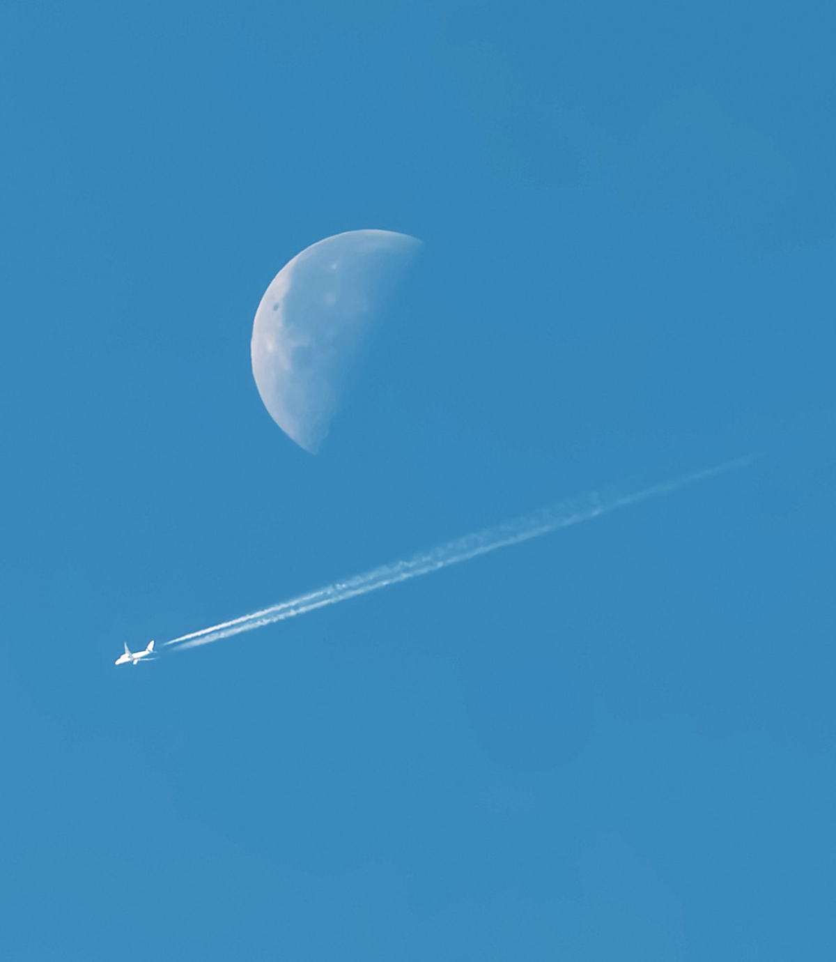La estela de un avion y la luna. Foto de Pablo Varela